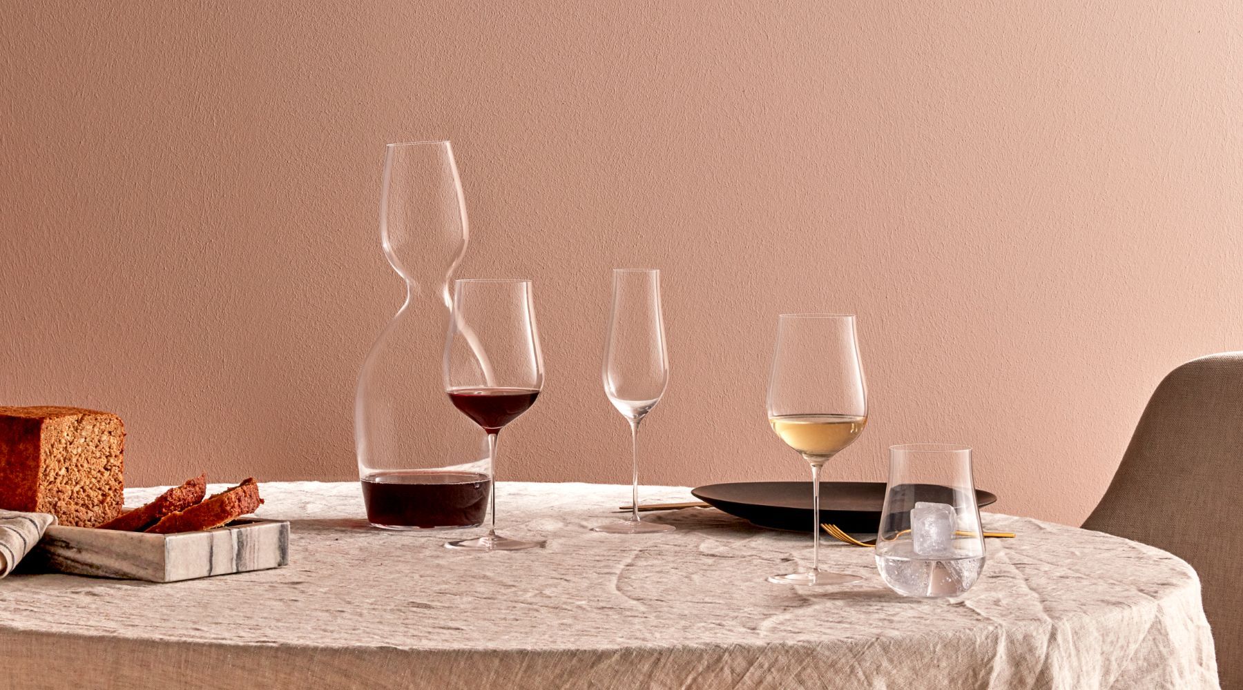 NUDE Ghost Zero Tulip glass collection, which have a tulip shape, presented on a table with the NUDE Red or White decanter