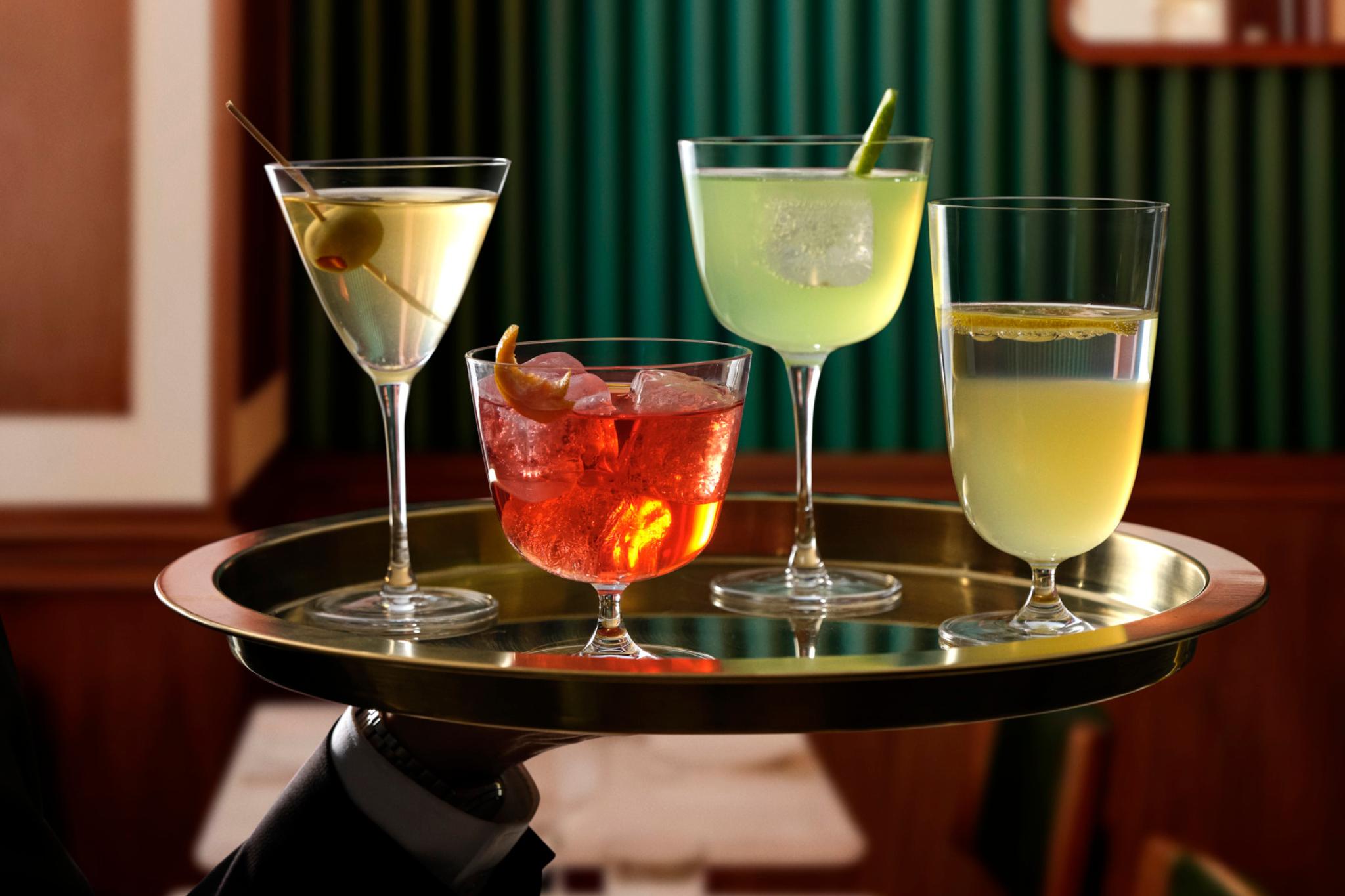 NUDE Bar/giani martini, cocktail short, long-stem and long cocktail glasses served on a brass tray in a green-panelled bar