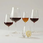 NUDE Salute crystal glassware collection with red wine, Burgundy, sherry glasses and a tumbler with lemon
