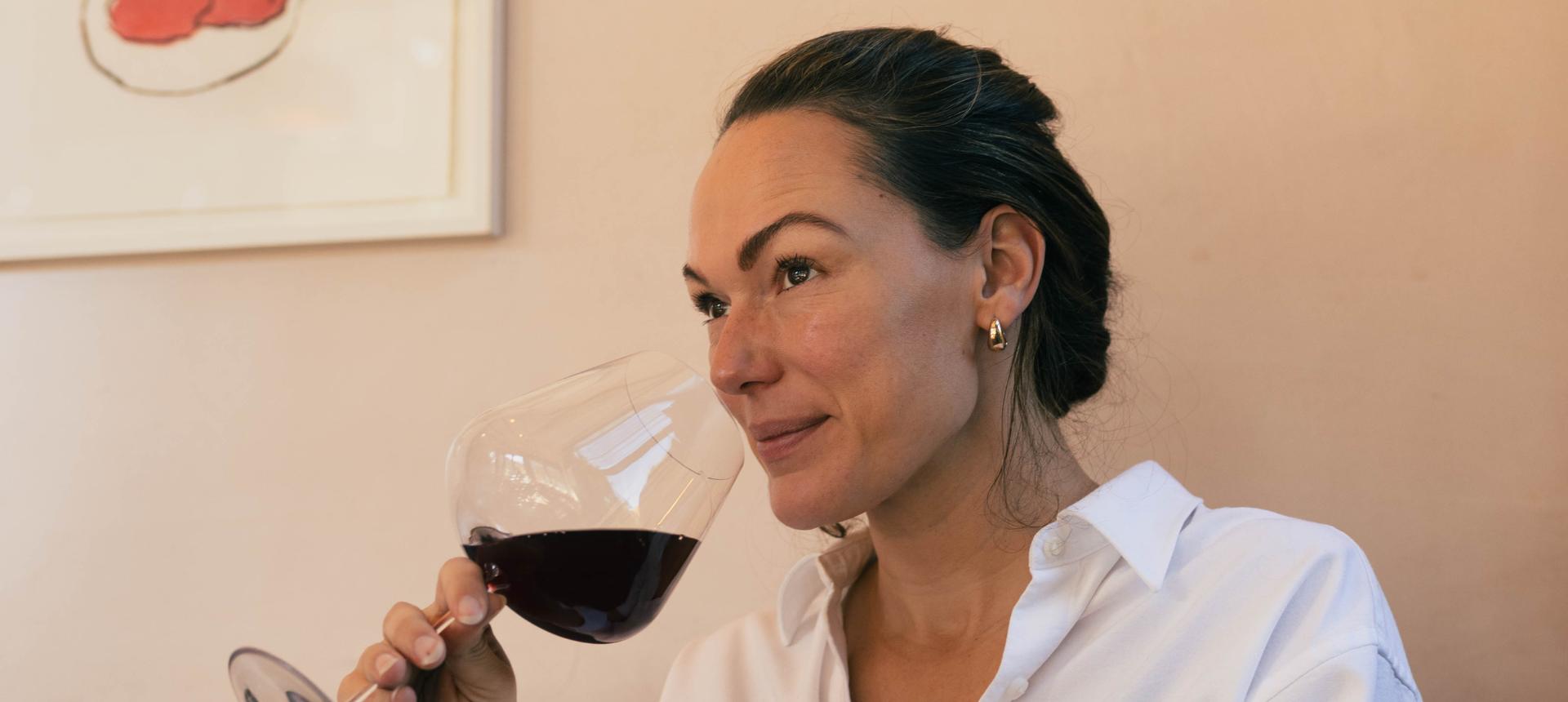 Sommelier Honey Spencer nosing red wine from a NUDE Stem Zero red wine glass.