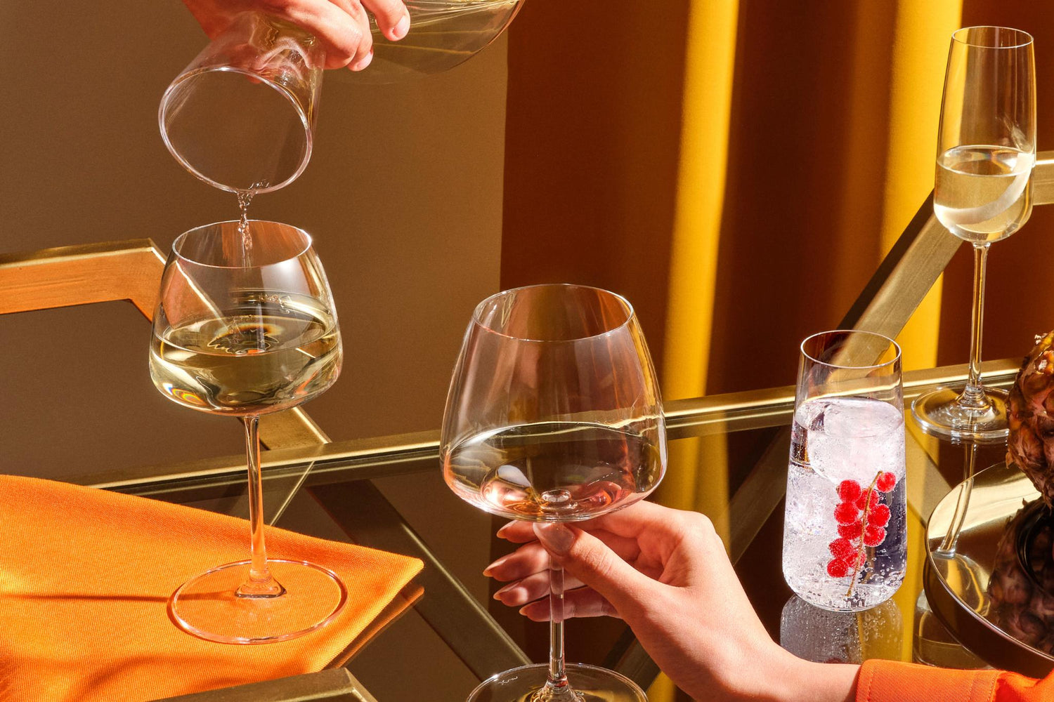 NUDE Mirage wine, champagne and water glasses being poured and served on a gold bar cart