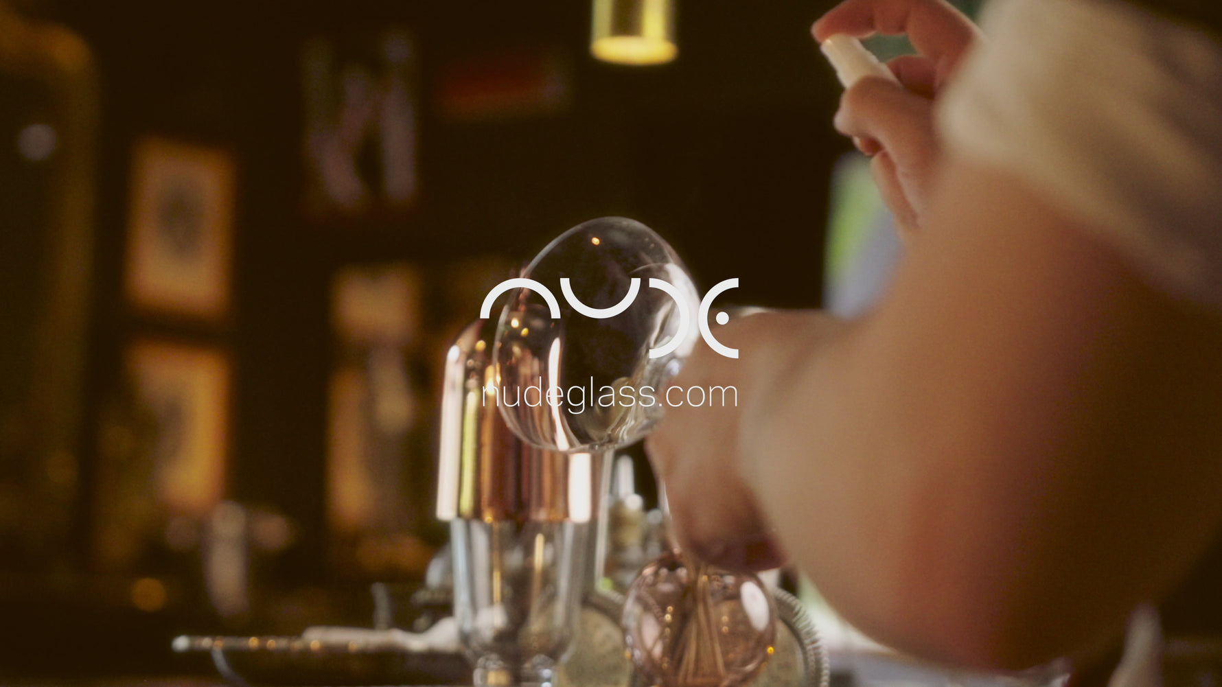 A bartender preparing cocktails in NUDE Hepburn coupe, highball and alchemy glasses in a cocktail bar.