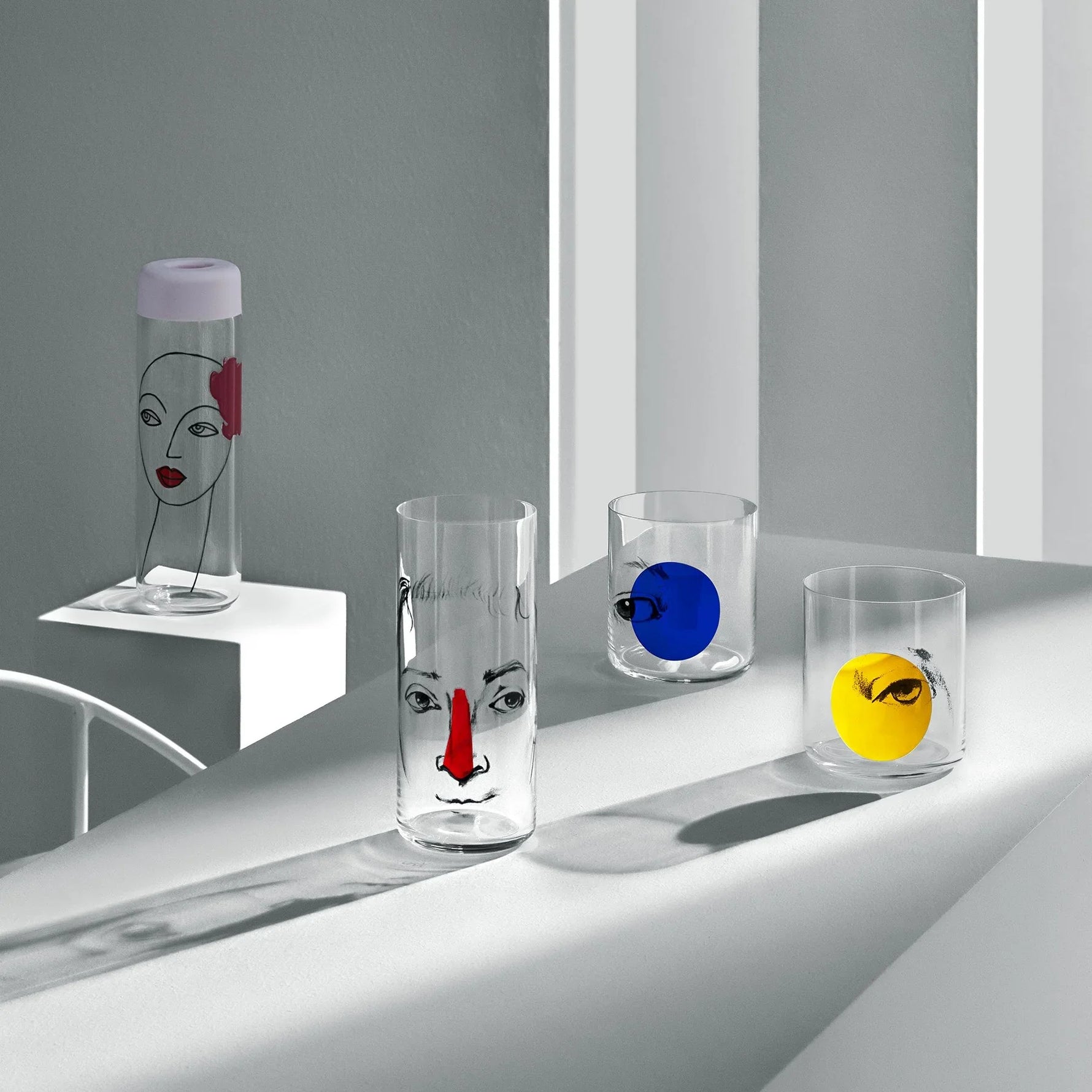 Lifestyle image of NUDE Rock & Pop glass collection with jug, highball glass and whisky glass in light neon environment