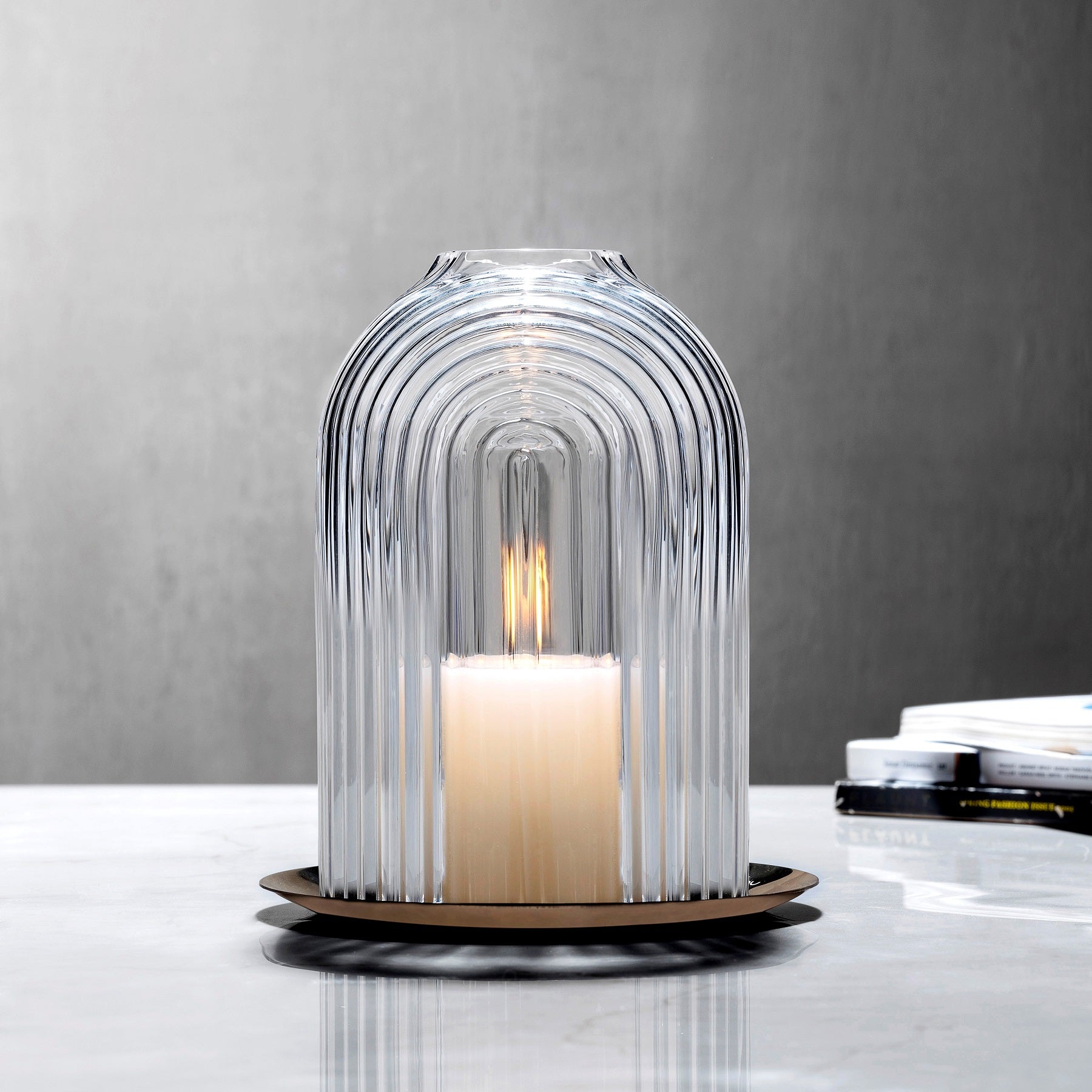 Lead-free crystal candle holder Ilo, a dome shaped candle holder with rippled glass effect, with candle presented on a table with grey tones