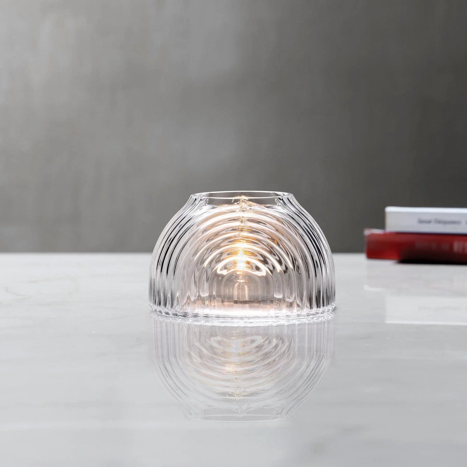 Lead-free crystal dome shaped votive with a rippled design, presented with votive on a table
