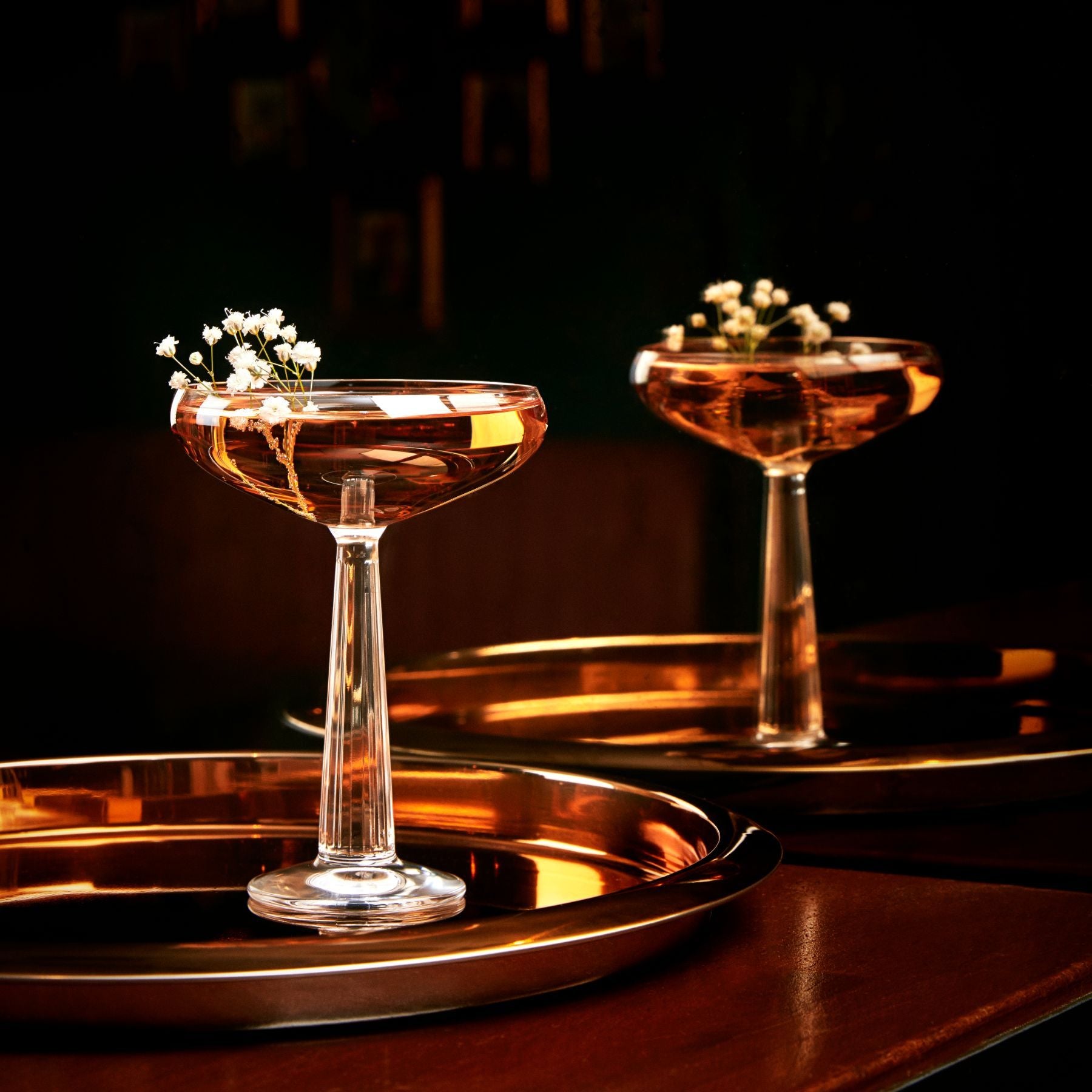 NUDE Big Top Coupe glass with linear patterned stem with elegant cocktail presented on a bar